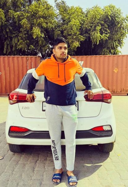 Nitesh Kumar posing with his car Hyundai i20