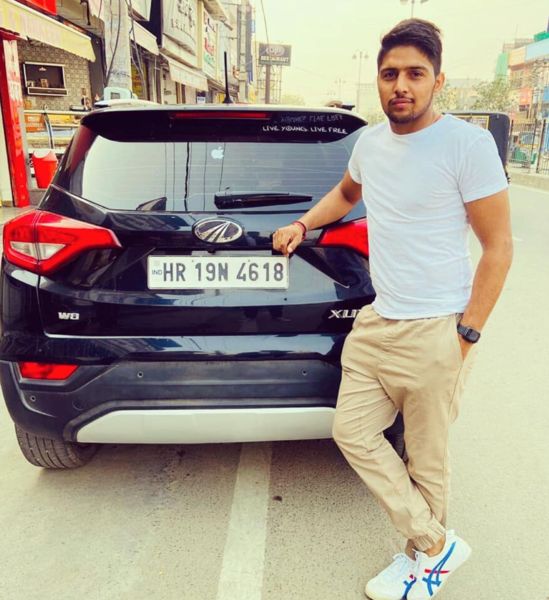 Nitesh Kumar posing with his car Mahindra XUV 300